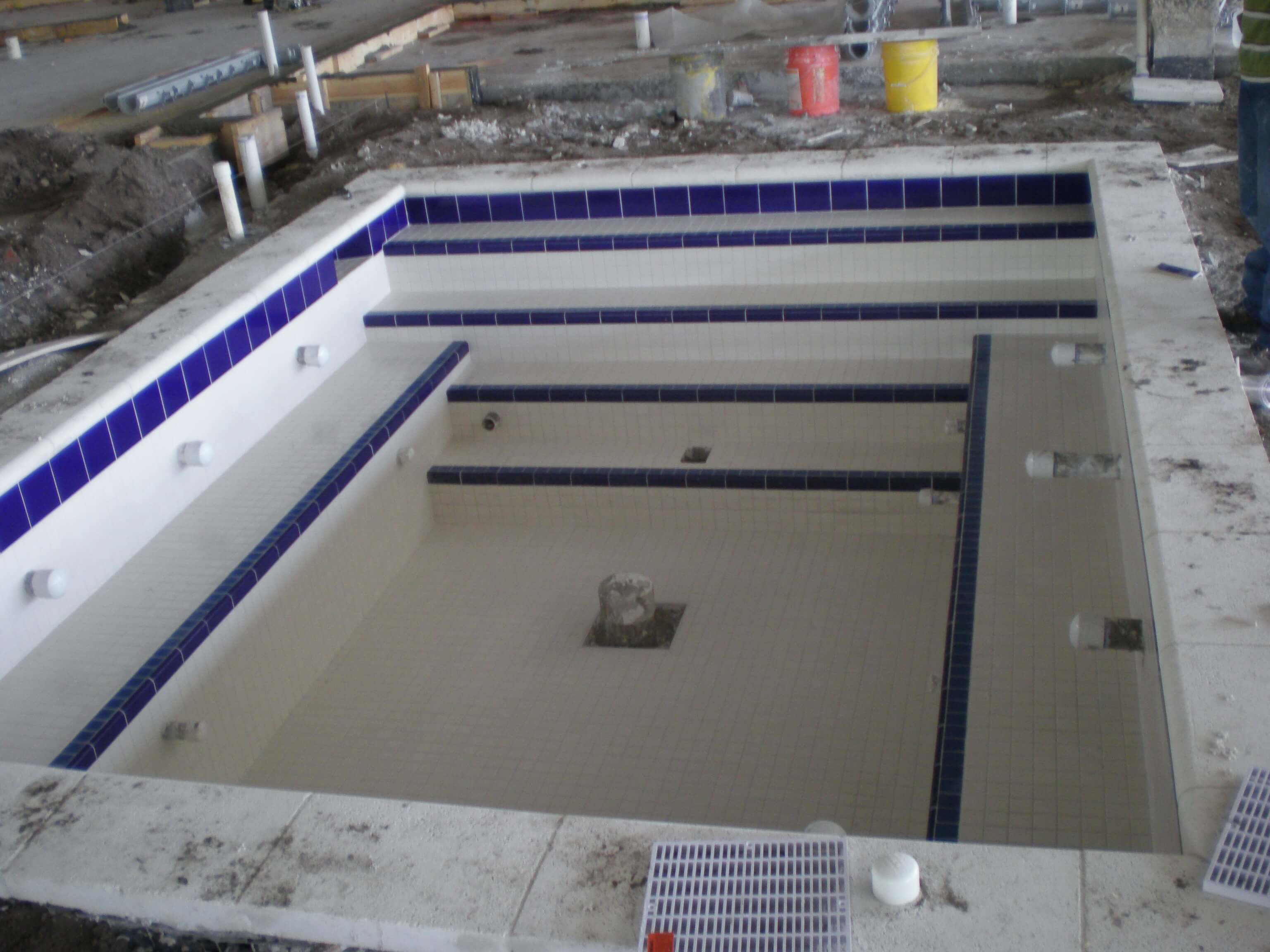 Jacuzzi area fully prepped with blue and white tiles installed, awaiting final construction steps.
