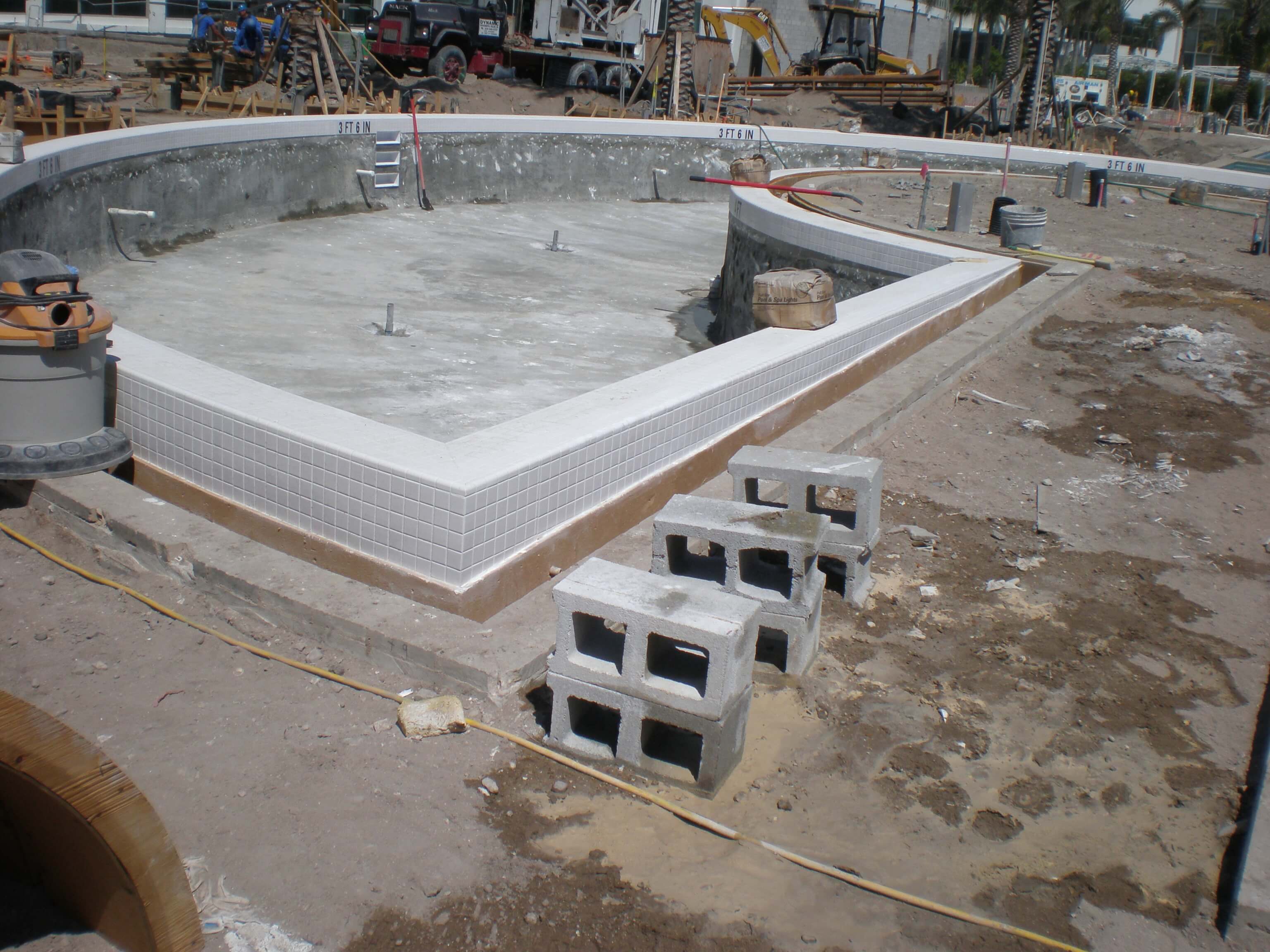 View of a partially completed pool with newly installed tiles around the edges at the Fontainebleau Miami Beach resort.