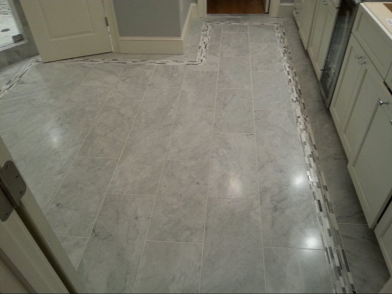 Polished marble floor with a decorative border in a modern bathroom.